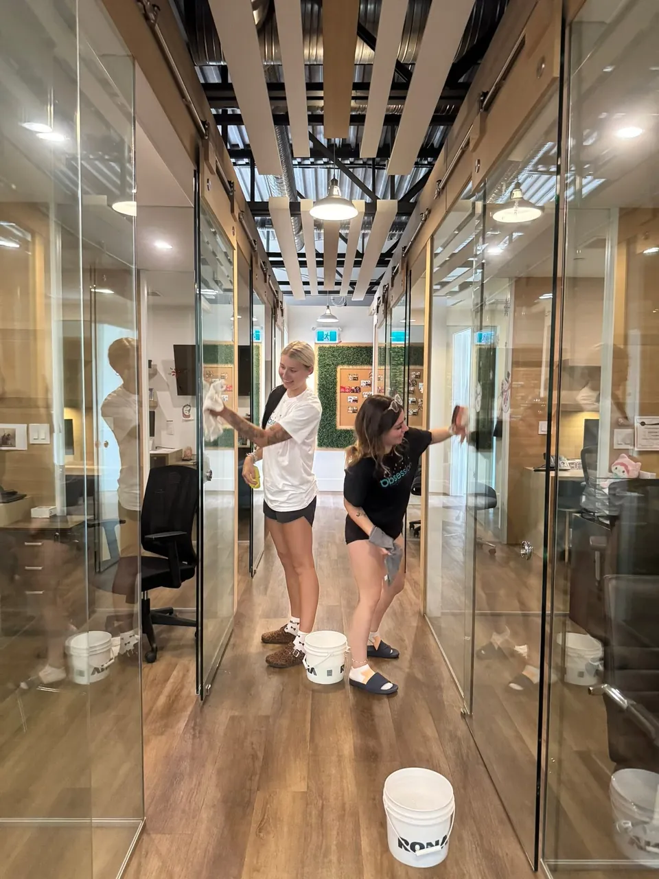 Two Cleaning Technicians cleaning glass office walls