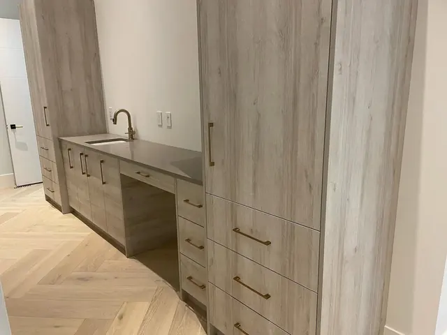 Clean empty room with built-in cabinets and herringbone flooring