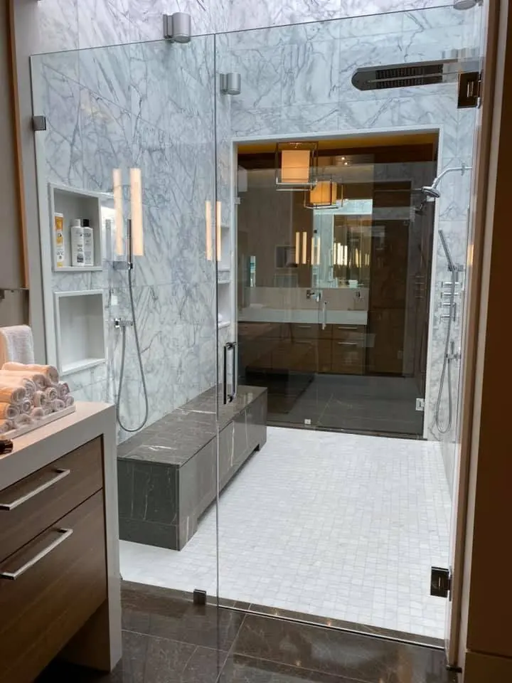Clean glass shower doors and polished tile in a residential bathroom
