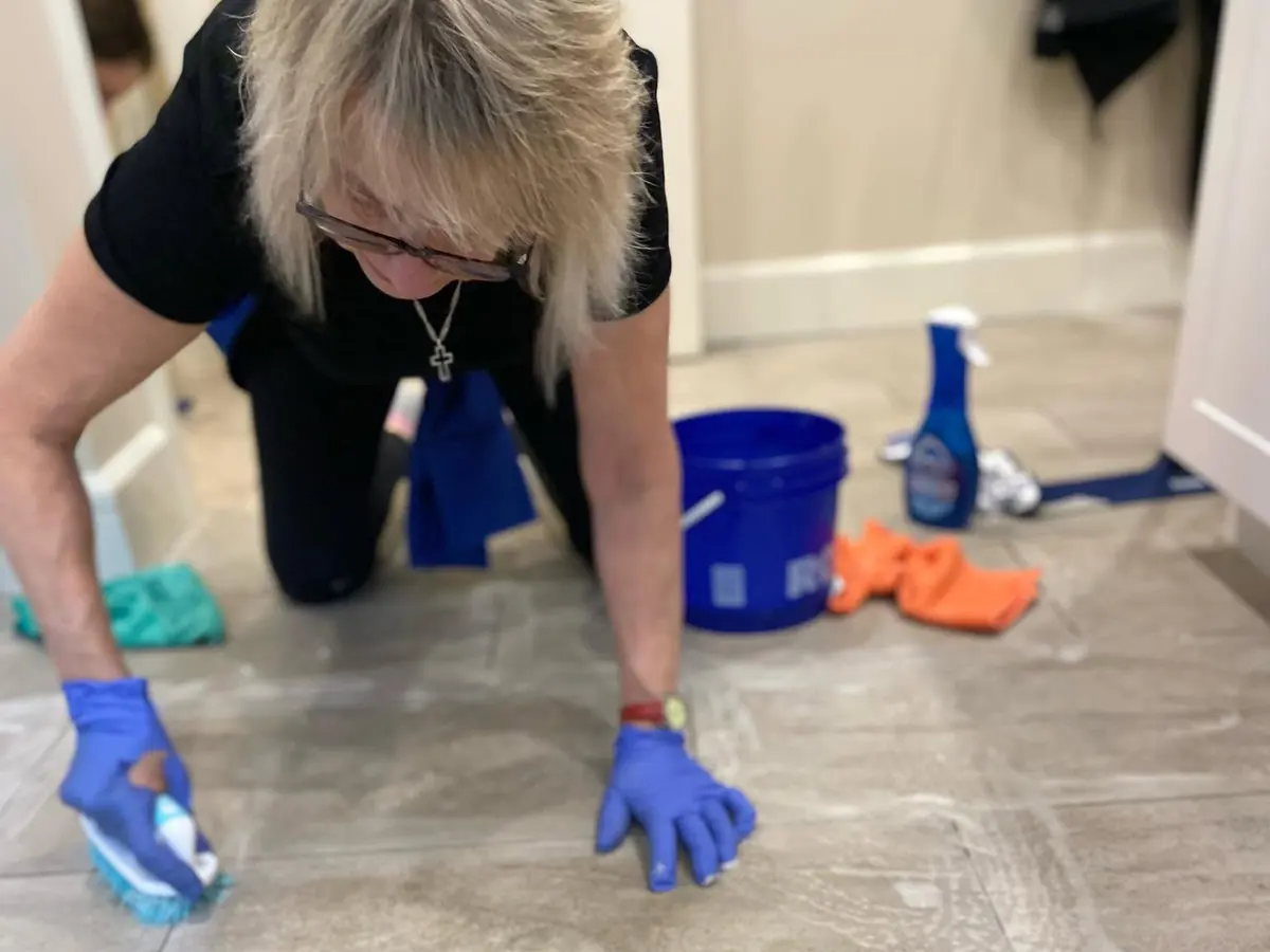 Cleaning Technician hand-cleaning tile flooring